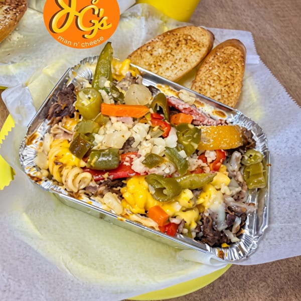 Joey G's Man n' Cheese with beef, peppers, and onions, served with garlic bread.
