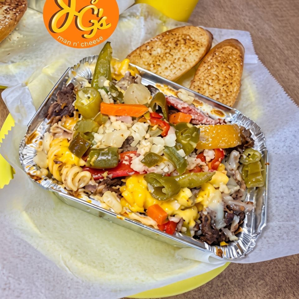 Joey G's Man n' Cheese with beef, peppers, and onions, served with garlic bread.